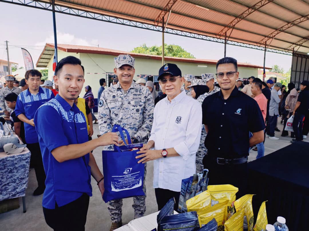 Wakil Ko-Nelayan Wilayah Pantai Barat menyampaikan cenderahati kepada Laksamana Pertama Maritim Mohd Khairulanuar Bin Abd Majid @ Razali di gerai pameran Program Sahabat Maritim, Kg. Kuala, Papar